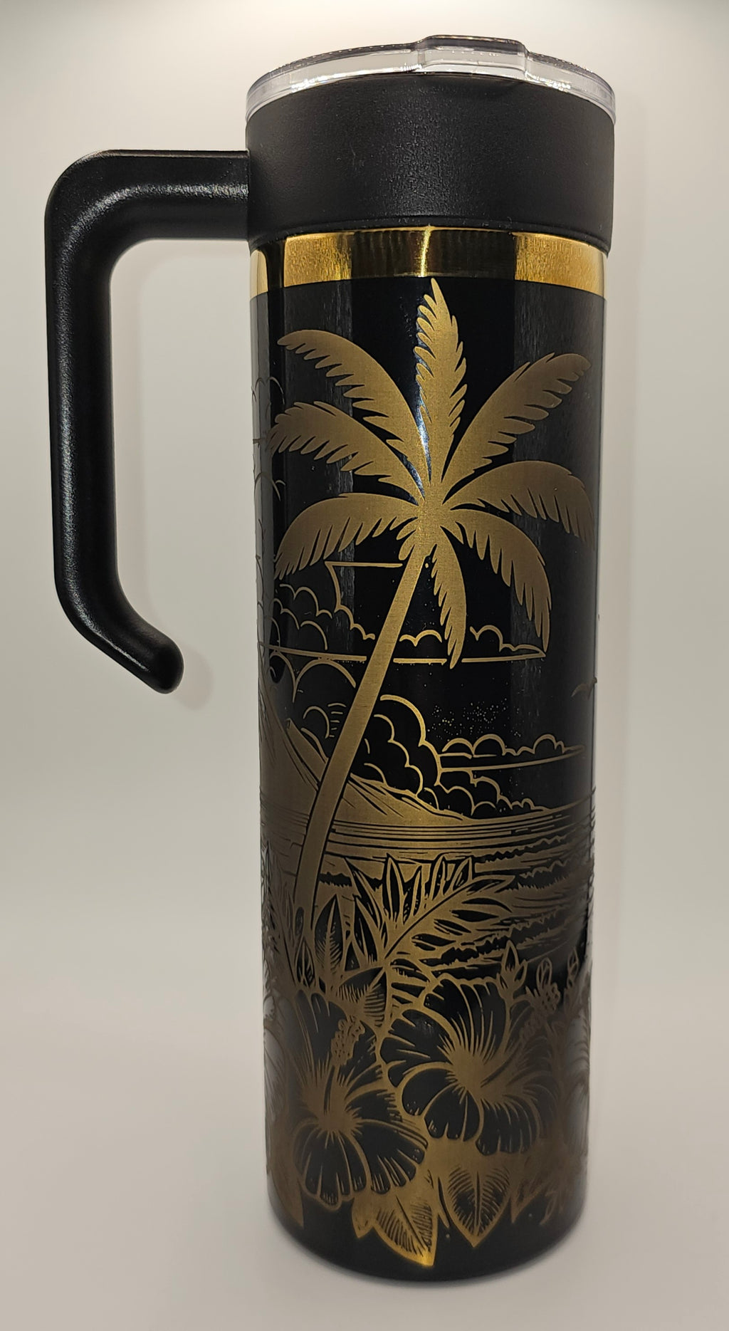 Black tumbler with gold palm tree and leaf design on a white background