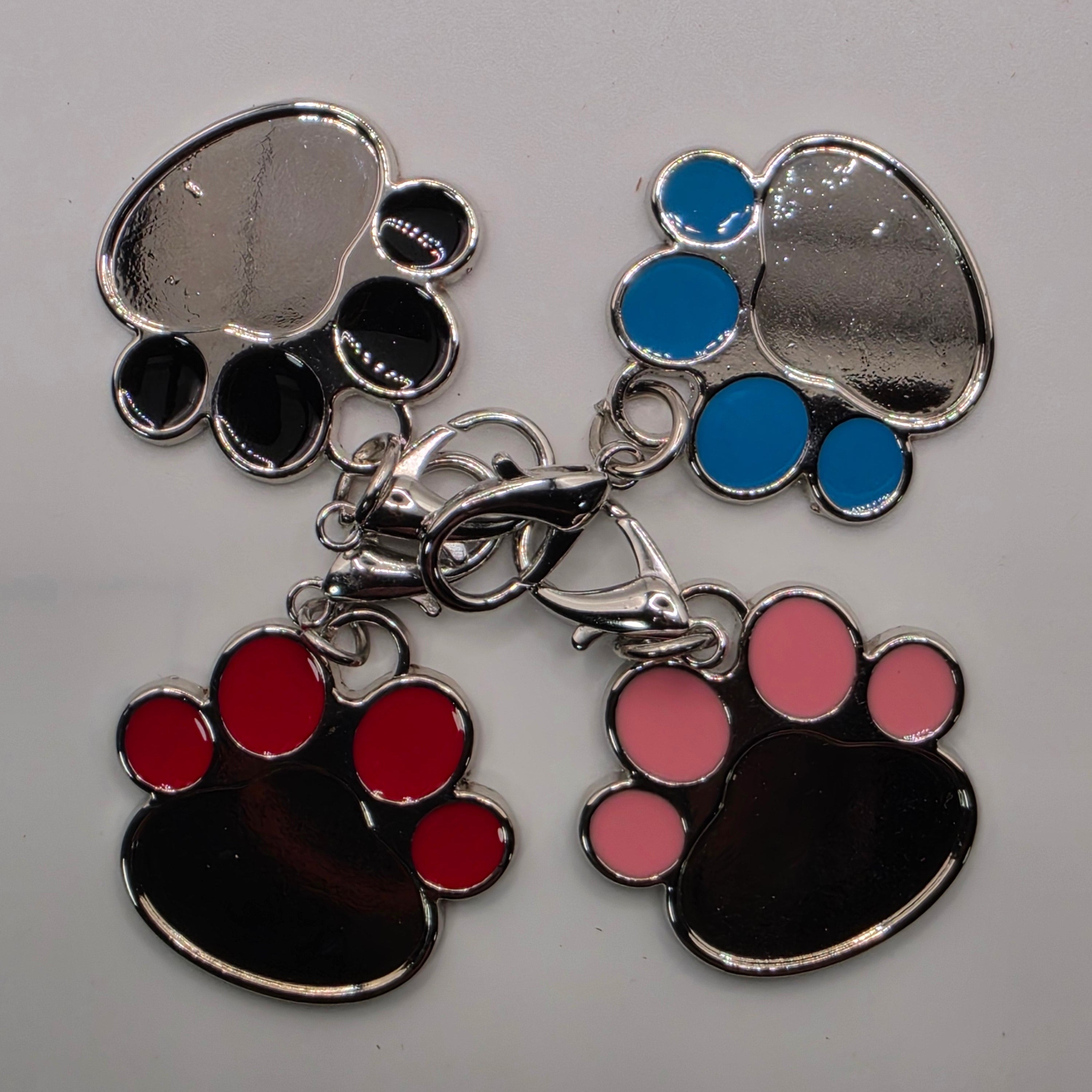 Set of colorful paw print charms on a gray background