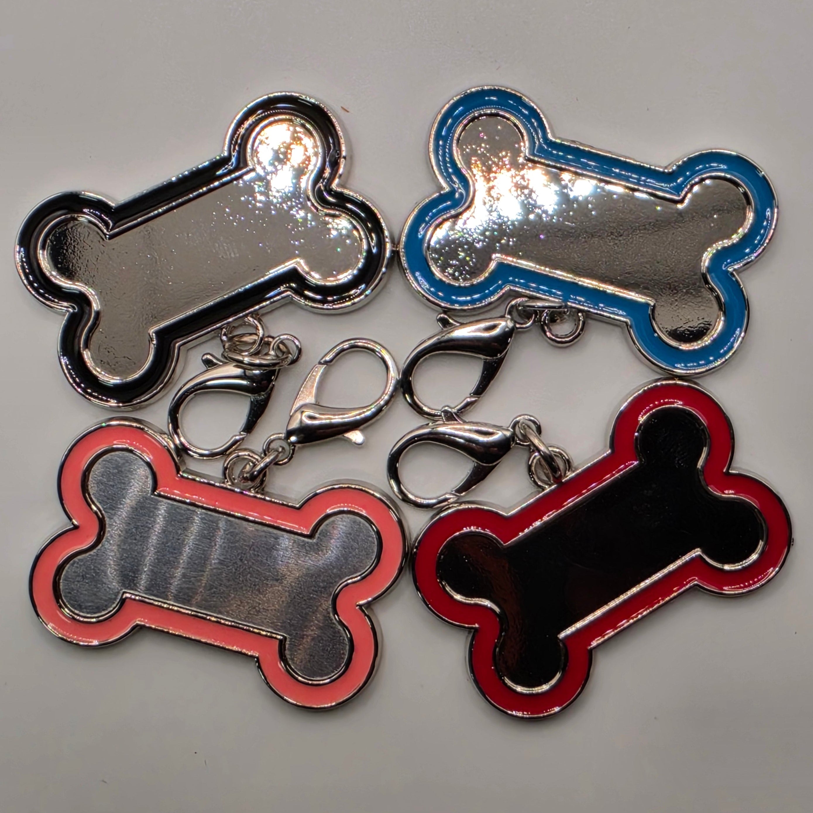 Four bone-shaped keychains in red, blue, pink and black