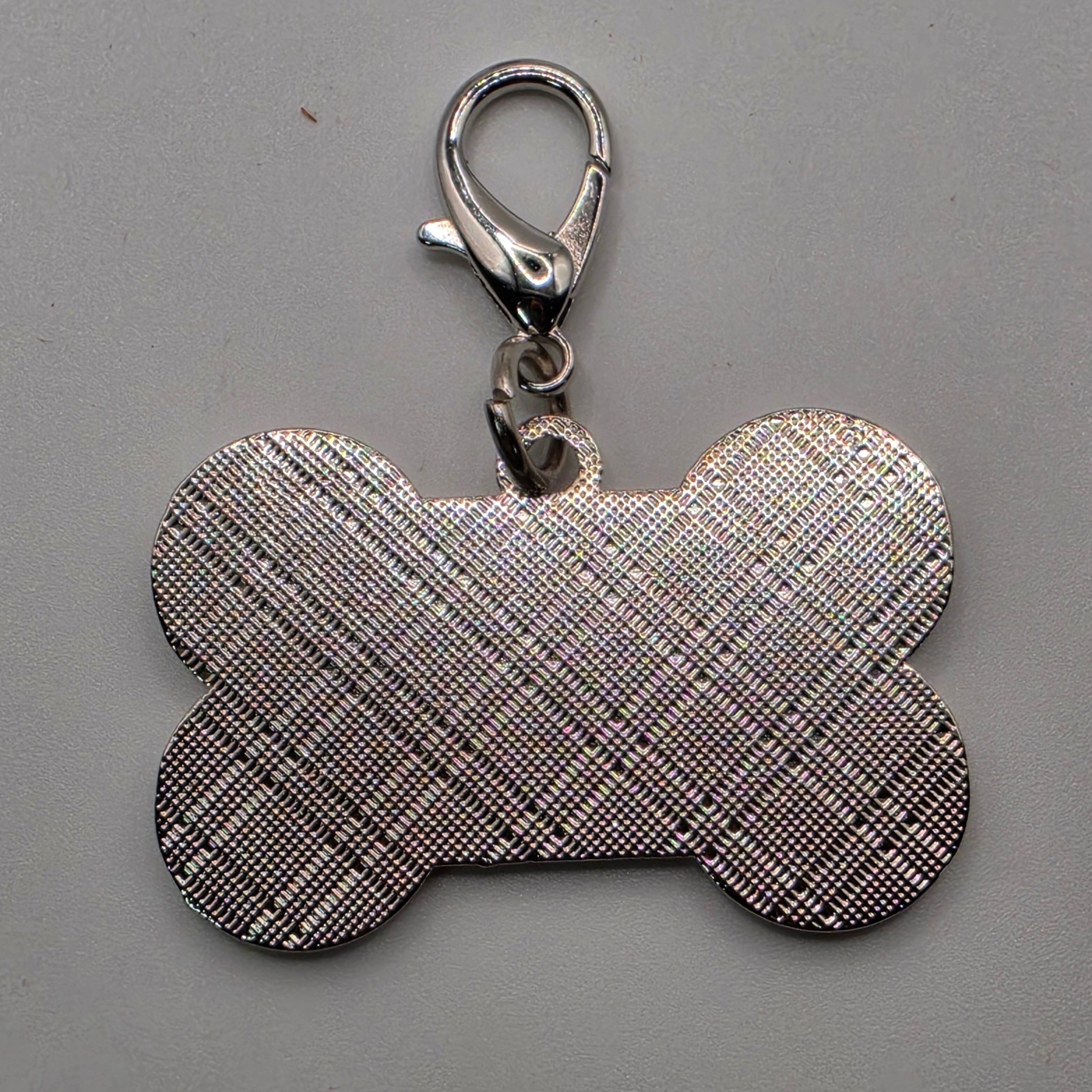 Dog bone-shaped keychain with plaid pattern on a gray background