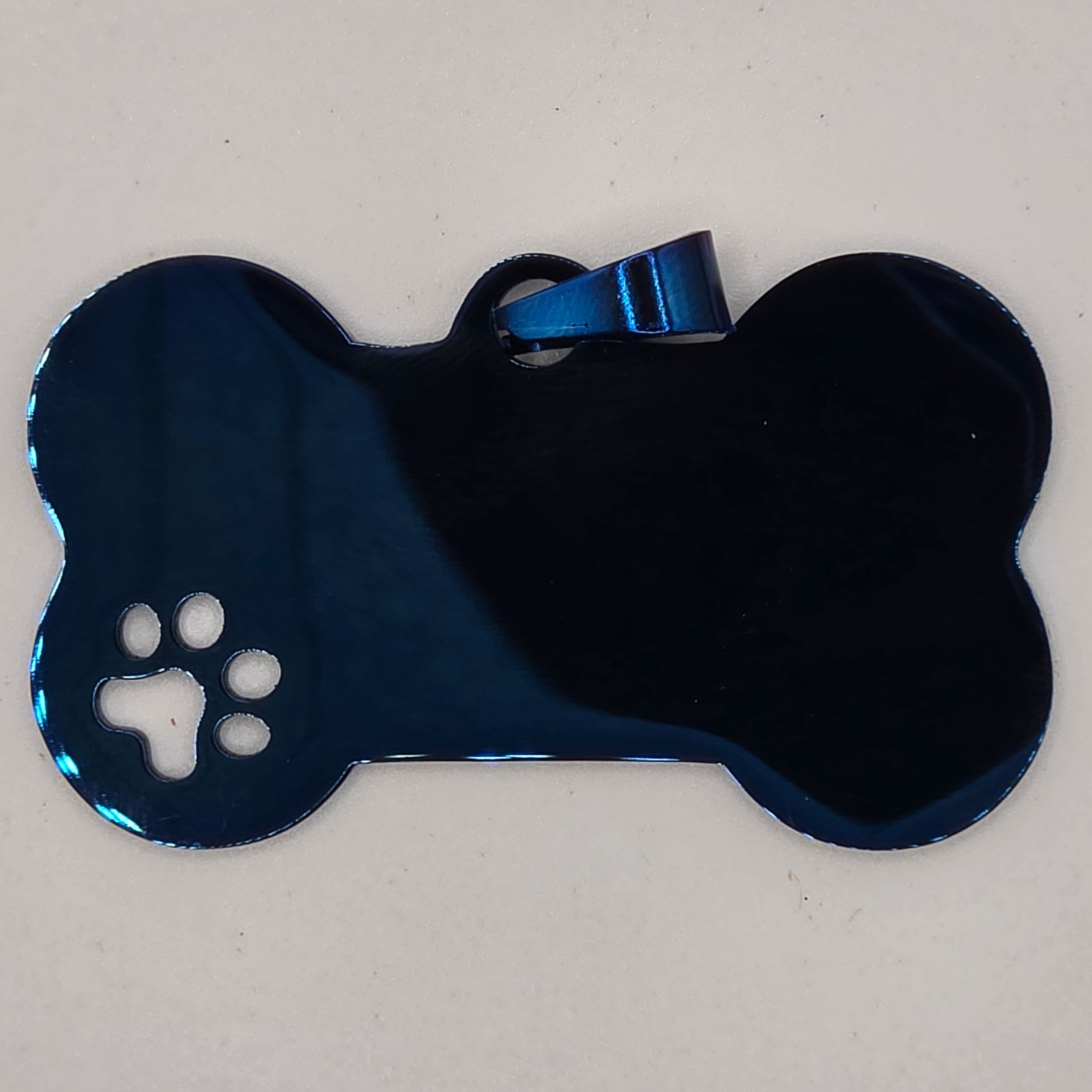 Blue bone-shaped pet toy with a paw print on a light gray background