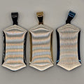 Three metallic hair clips on a gray background