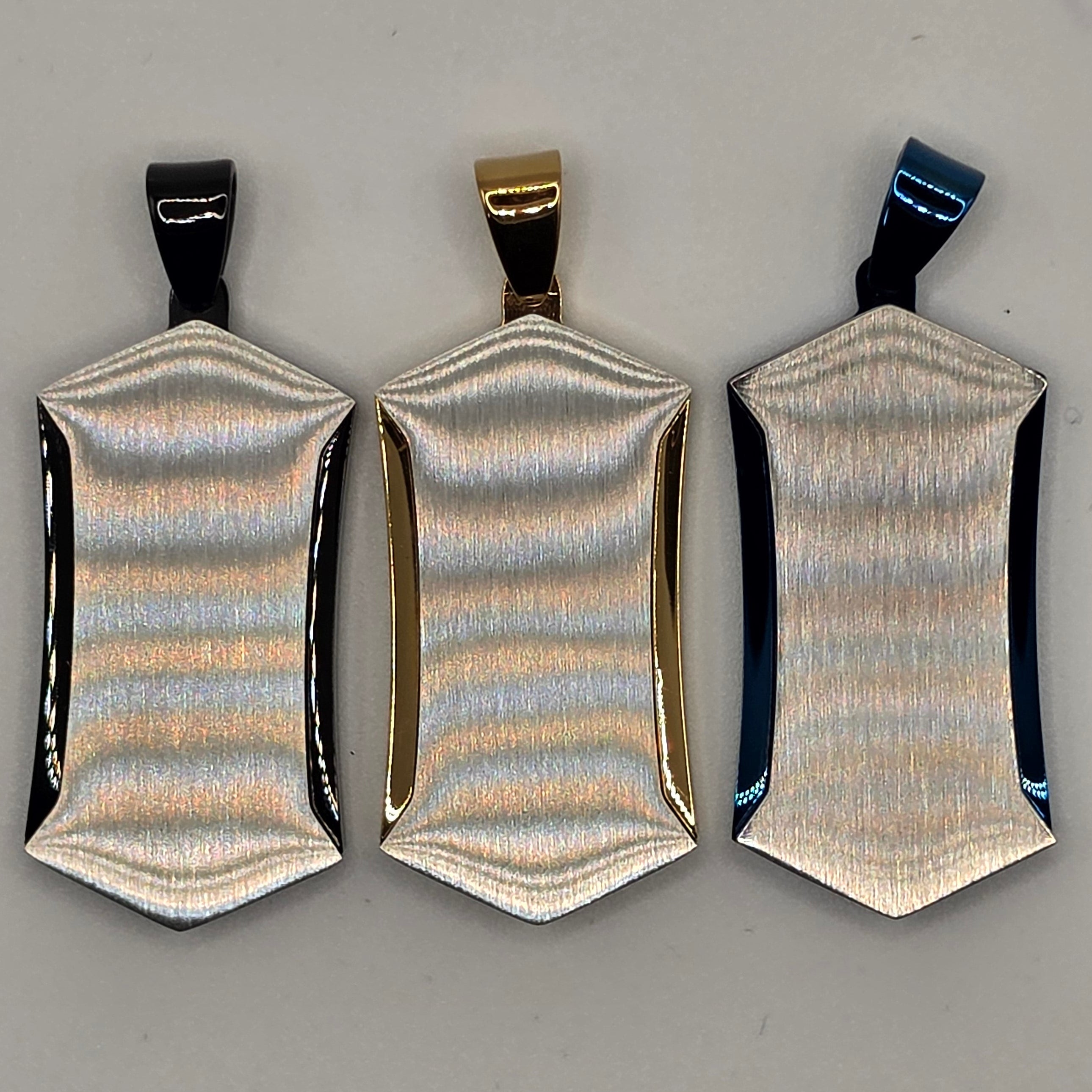 Three metallic hair clips on a gray background