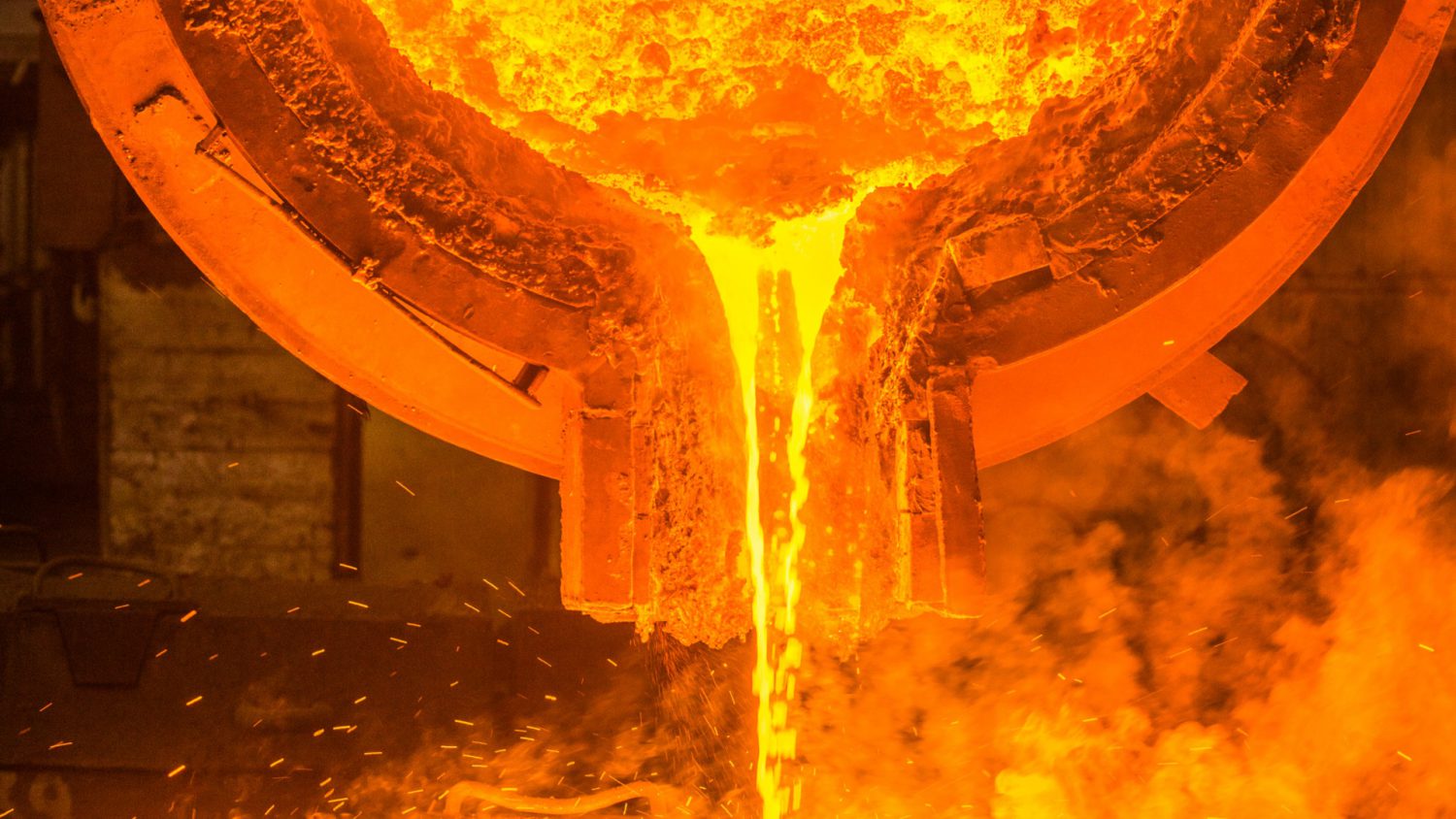 Molten metal being poured into a mold with a glowing orange hue.