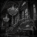 Ornate interior with chandeliers, floral arrangements, and a piano.