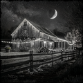 Decorated barn at night with string lights and a full moon.