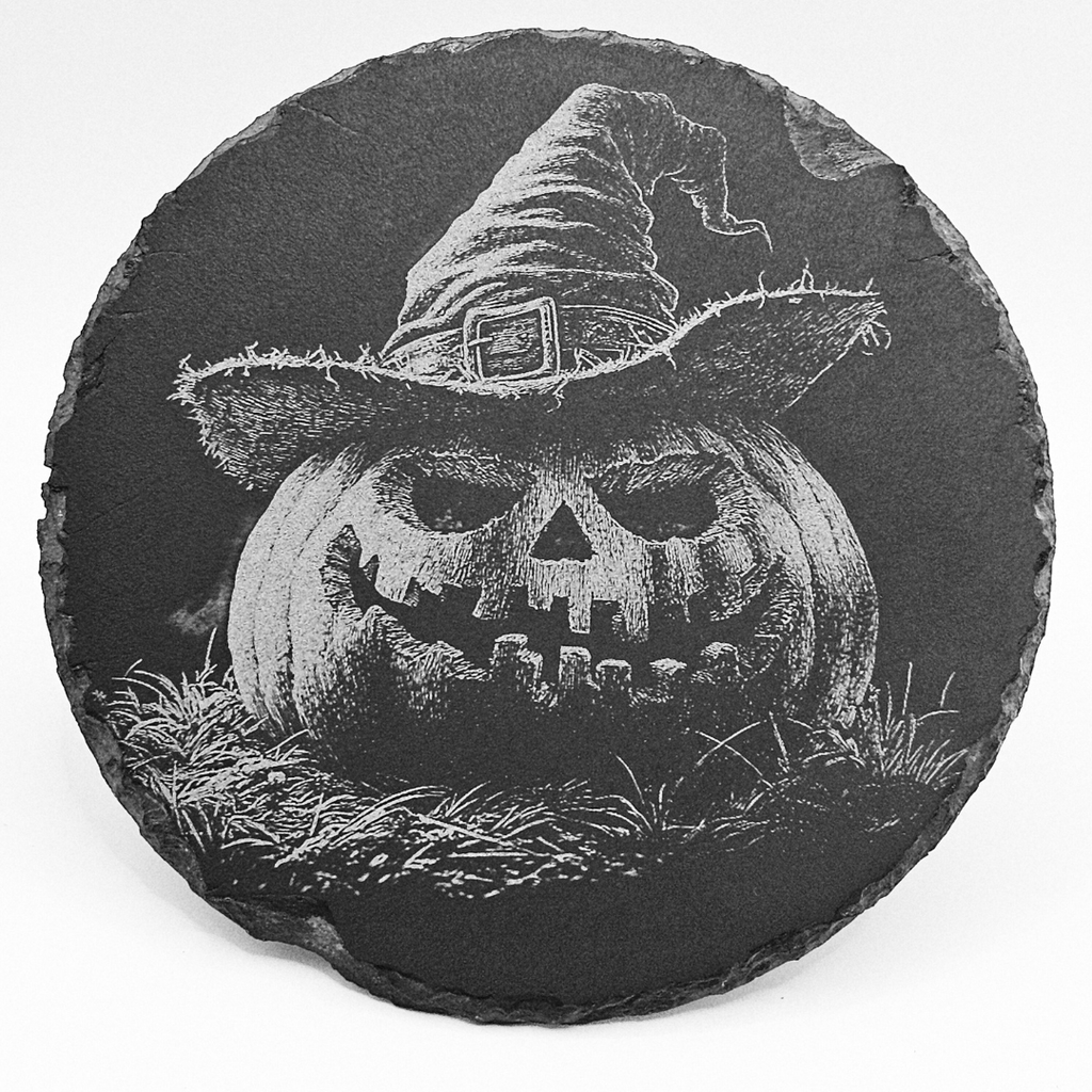 Round slate coaster with a carved pumpkin wearing a witch hat on a white background