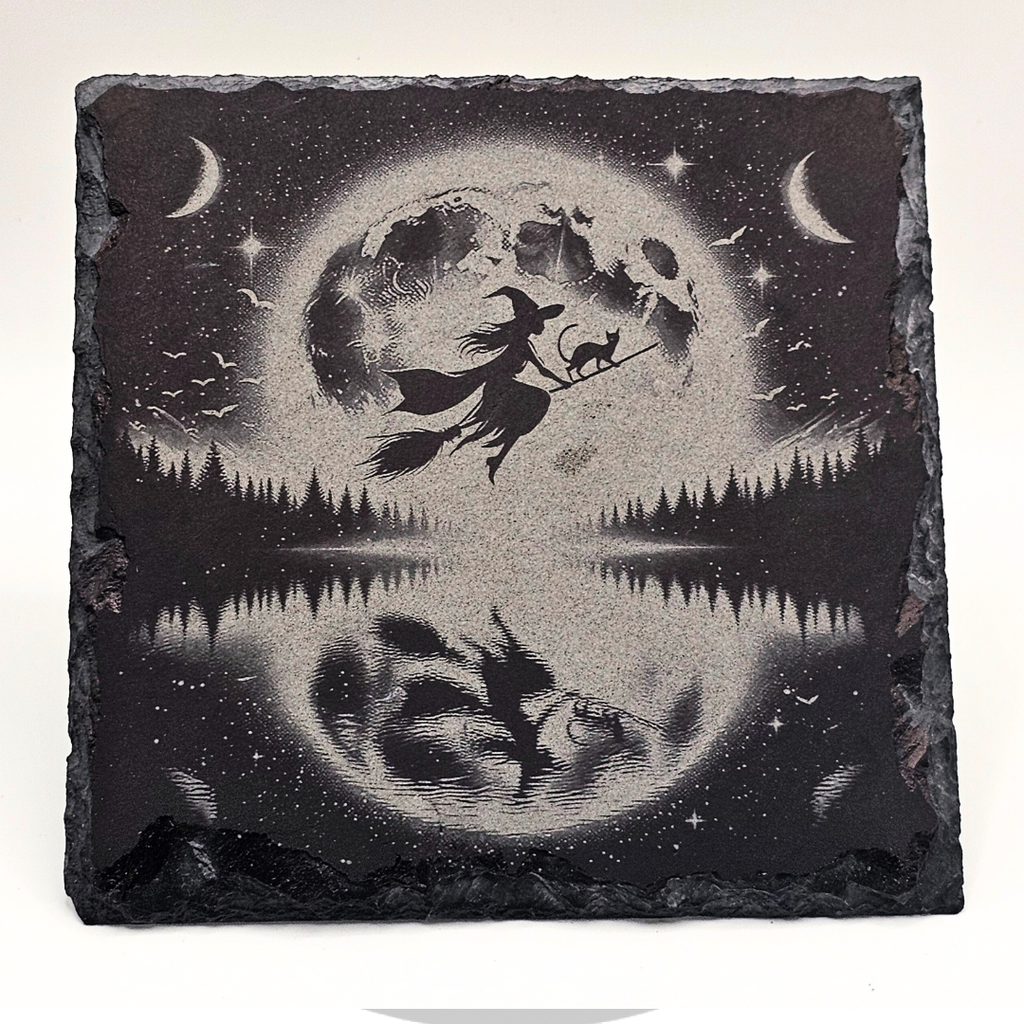 Decorative slate with a witch and cat design against a moonlit sky