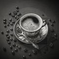 Black and white cup of coffee with beans on a textured surface