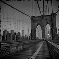 Black and white view of the Brooklyn Bridge towards the Manhattan skyline