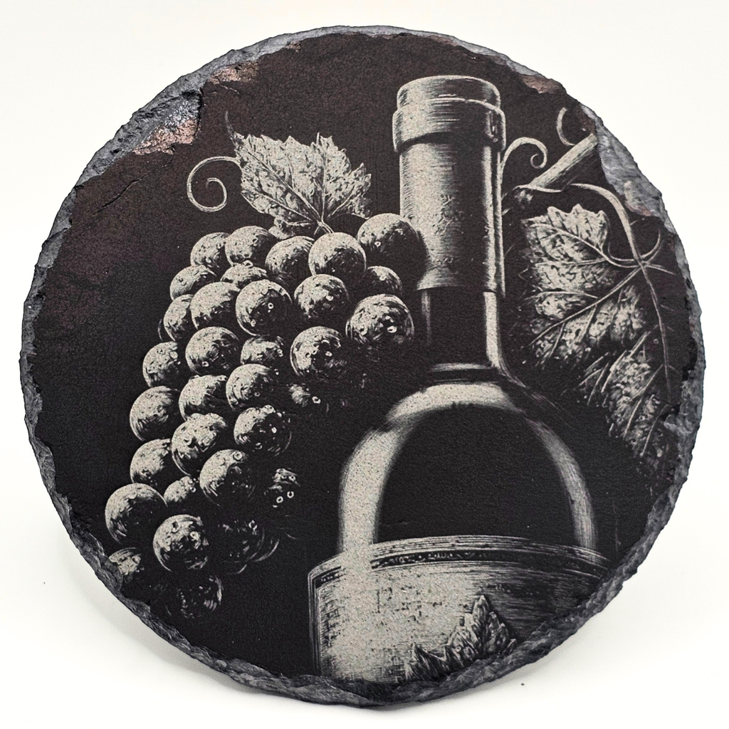 Decorative stone with engraved design of a wine bottle and grapes on a white background