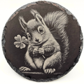 Round slate coaster with a black and white illustration of a squirrel holding a four-leaf clover.