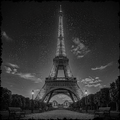 Black and white image of the Eiffel Tower under a starry night sky.