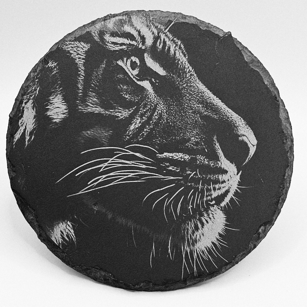 Round slate coaster with a engraved tiger design on a white background