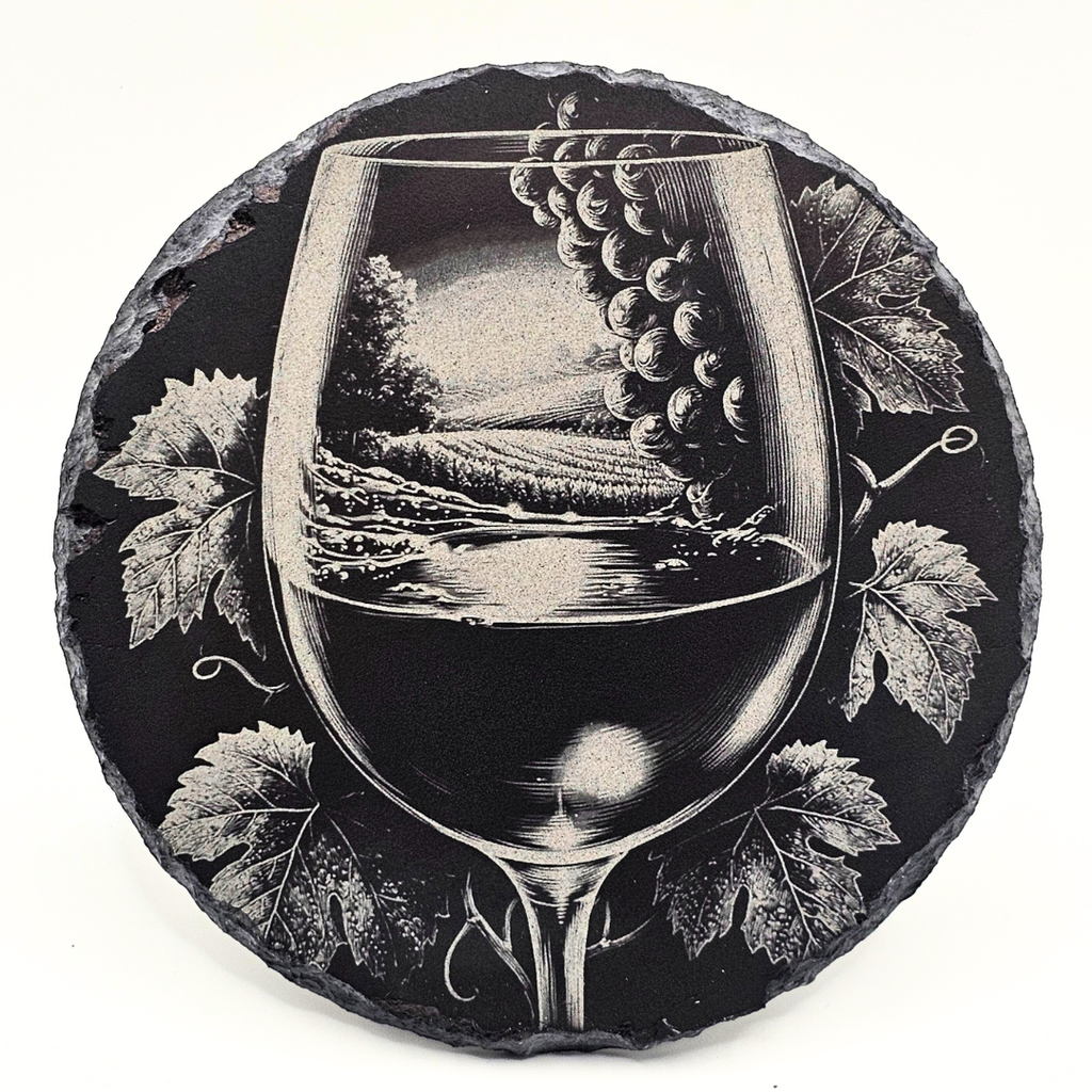 Decorative stone coaster with a wine glass and grapes design on a black background