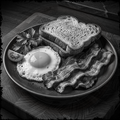 Black and white plate of toast, eggs, and bacon on a wooden surface