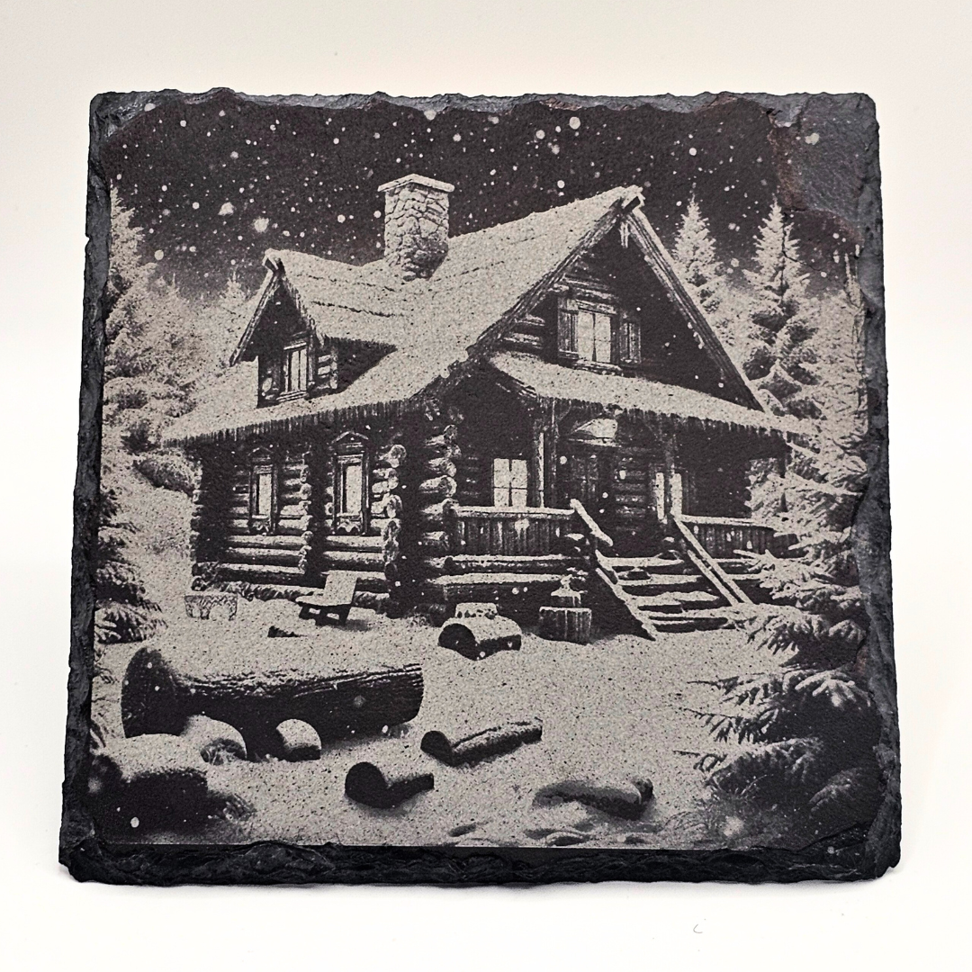 Decorative stone with a engraved image of a log cabin in the woods.