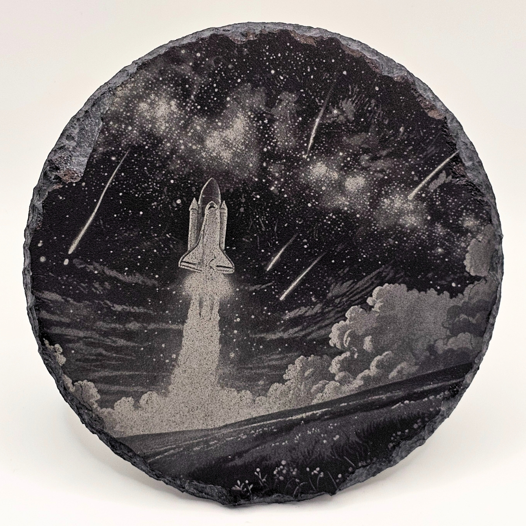 Decorative stone with a space shuttle launch design against a starry night sky.
