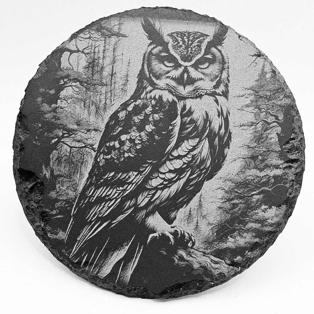 Round stone with an engraved owl in a forest setting