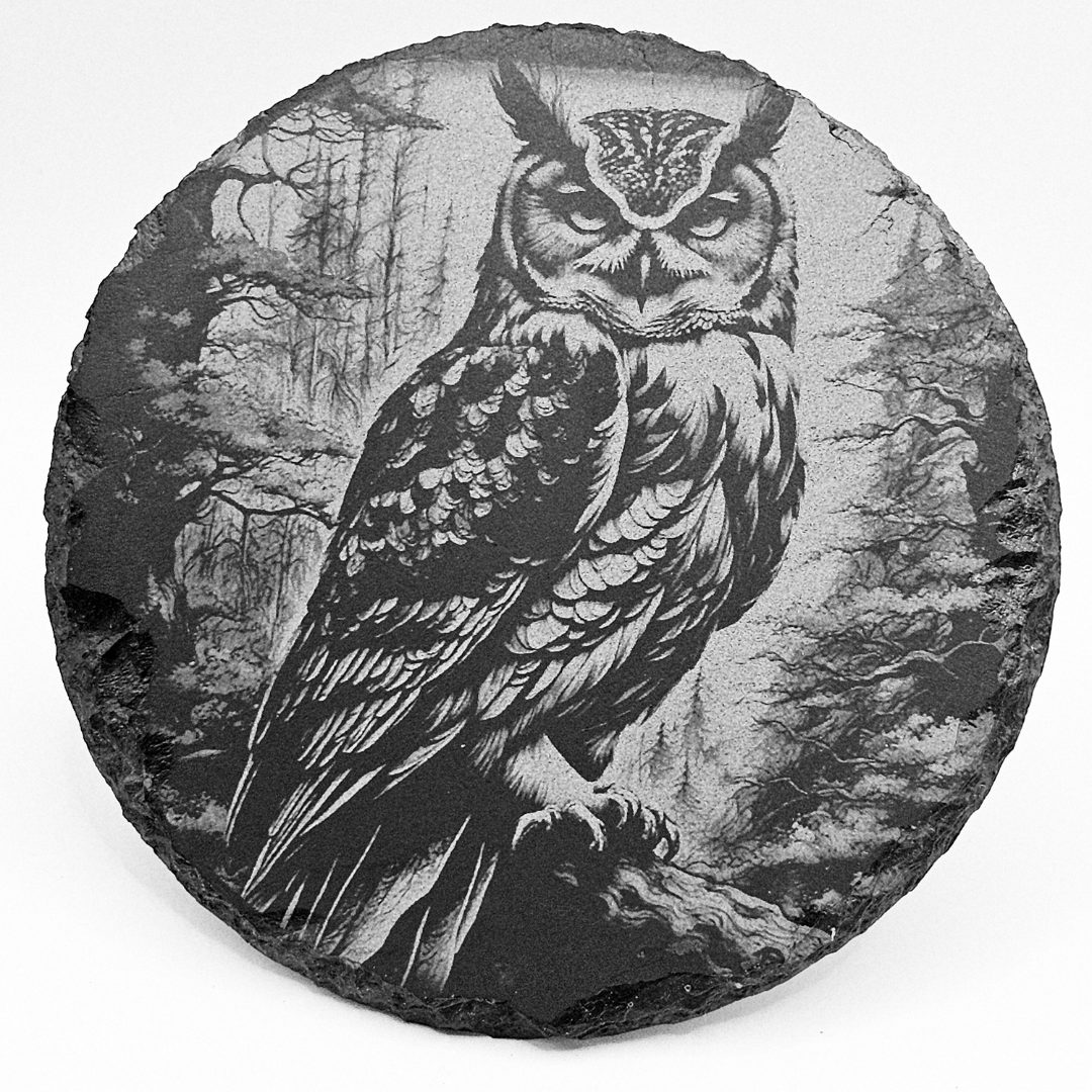 Round stone with an engraved owl in a forest setting