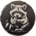 Round slate coaster with a raccoon holding a clover on a white background