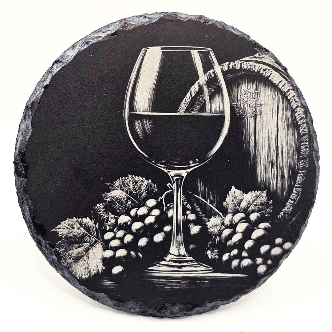 Round slate coaster with a wine glass and grapes design on a white background