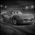 Animated race car with a smiling expression on a track at night.