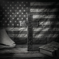 Vintage cross on a wooden surface with an American flag in the background