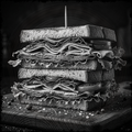 Stack of layered sandwich on a wooden board with a black background