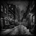 Cobbled street at night with snow, lit by street lamps and building lights.