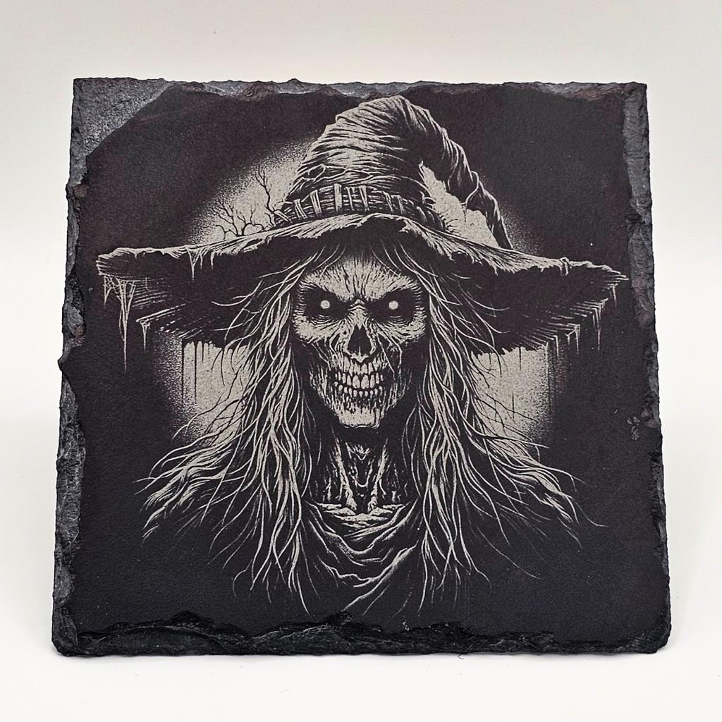 Black slate with a detailed design of a skeleton wearing a witch's hat on a white background