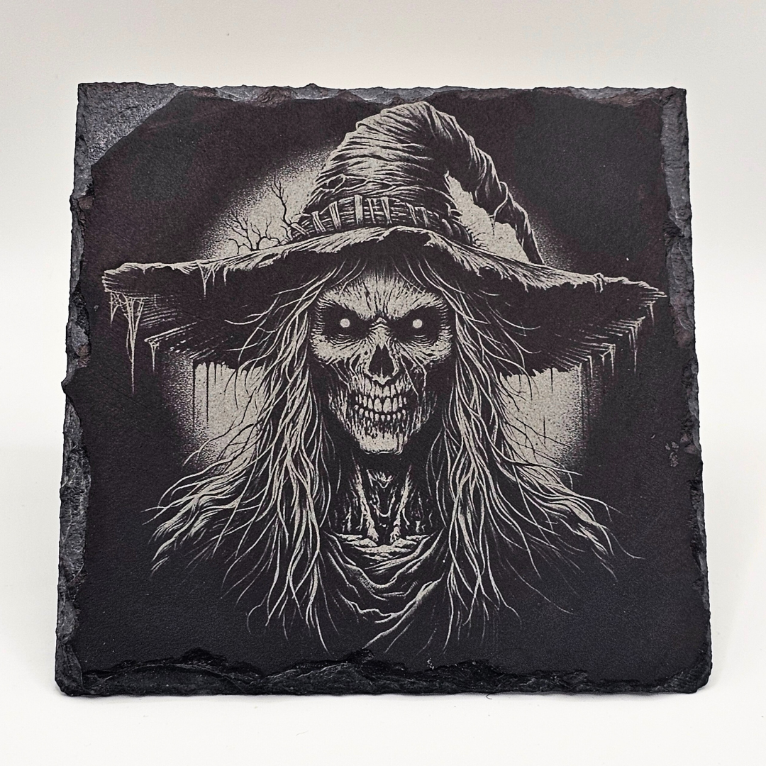 Black slate with a detailed design of a skeleton wearing a witch's hat on a white background