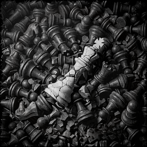 Close-up of a pile of chess pieces with a white star on a black background