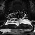 Open book with a crown of thorns on top, surrounded by religious items in a dark setting.