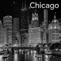 Black and white cityscape of Chicago with illuminated buildings and a river.