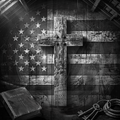 Wooden cross on an American flag with a Bible and keys in the foreground.