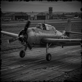 Vintage airplane on a runway with control tower in the background