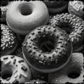 Black and white image of assorted donuts with different toppings.