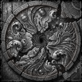 Decorative stone panel with intricate carvings and symbols, featuring a central spiral design.